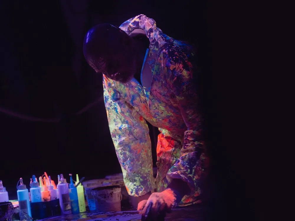 Ein Künstler verwendet Leuchtfarben für seine Kunst